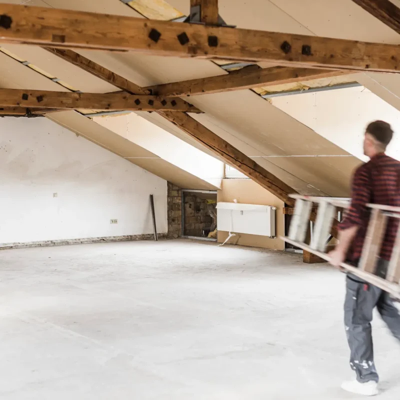 Man carrying ladder on costruction site